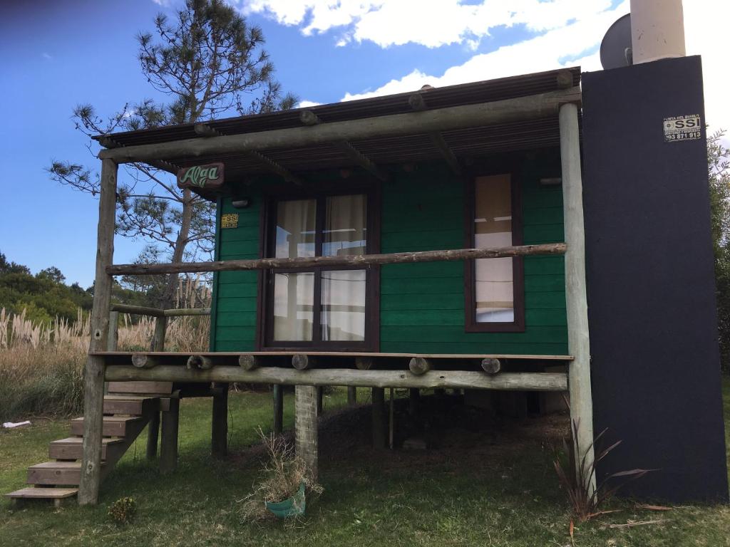 a green tiny house on a wooden platform at Alga in Punta Del Diablo