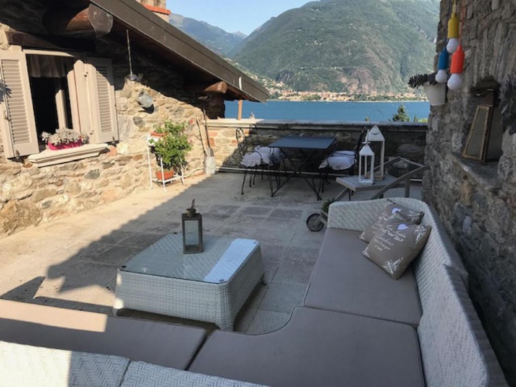 eine Terrasse mit einem Sofa und einem Tisch auf einem Gebäude in der Unterkunft L'antico Borgo in Cremia