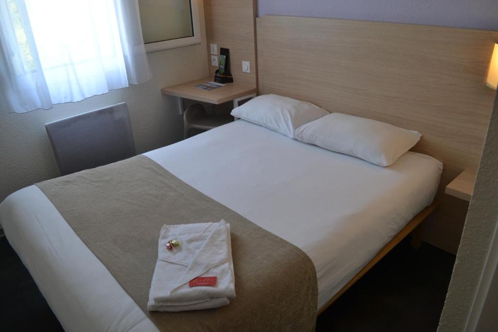 una camera d'albergo con un letto e un asciugamano sopra di Hotel Formule Club a Cenon