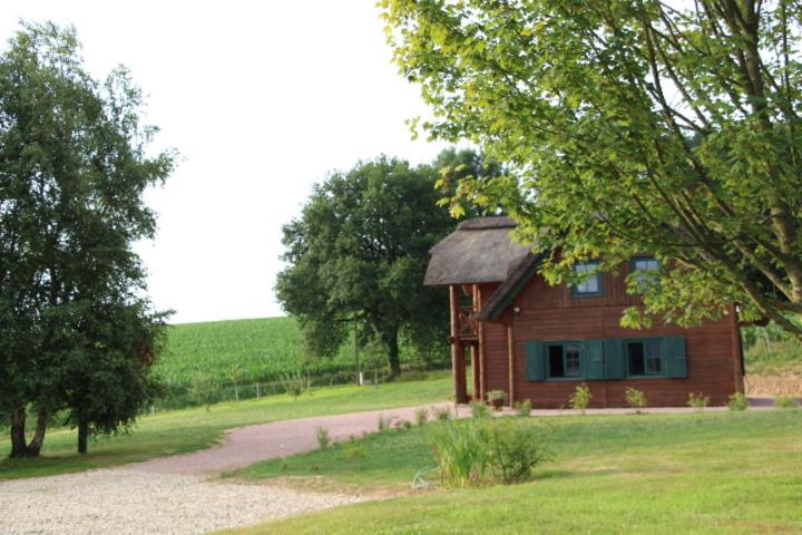a small wooden house in a field with a road at Chaumière d'Albâtre -Gîte-Détente nature et bien être in Ourville-en-Caux
