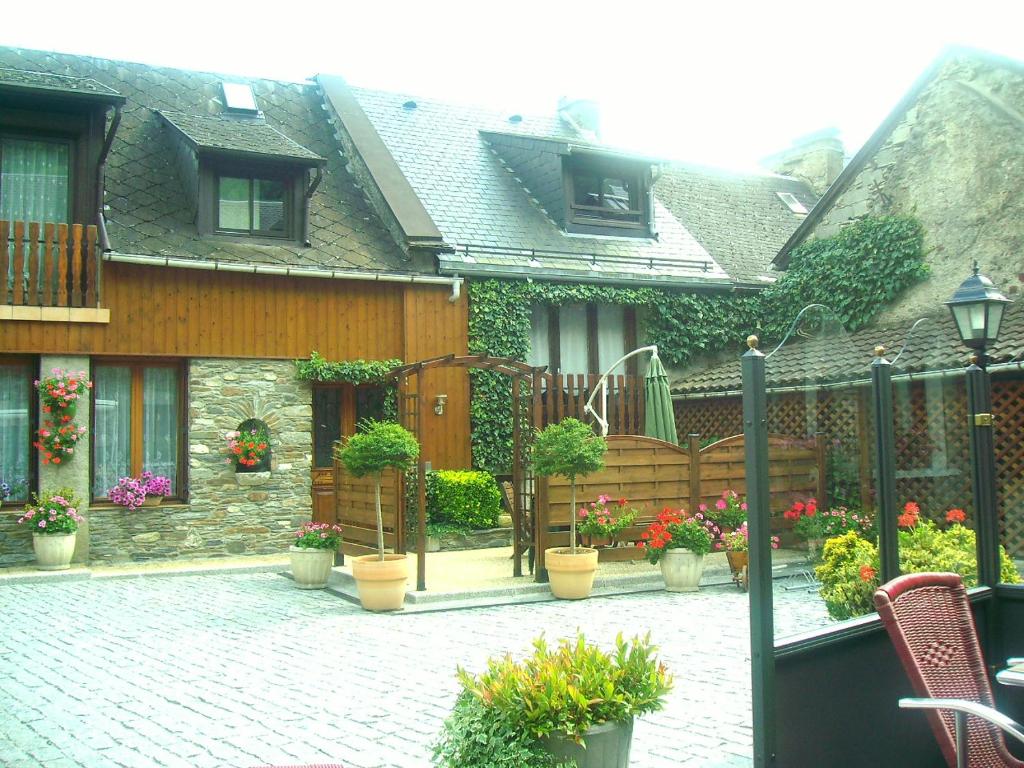 a house with a courtyard with potted plants on it at grand gite in Cier-de-Luchon