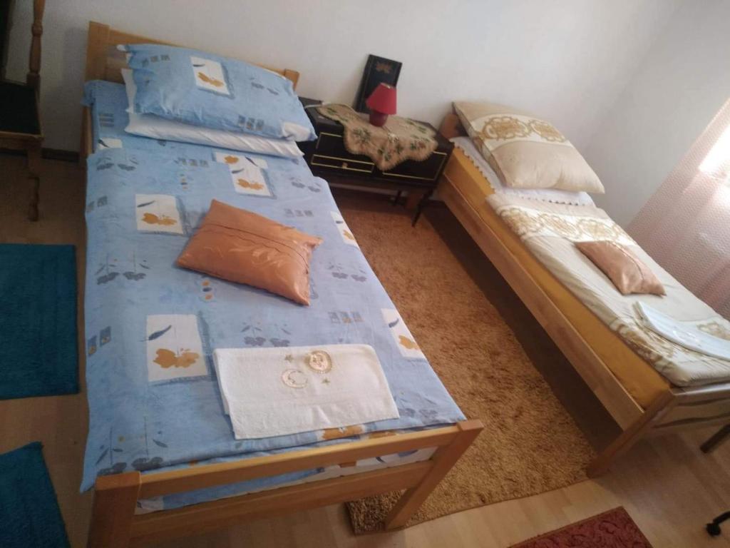 1 Schlafzimmer mit 2 Einzelbetten und blauer Bettwäsche in der Unterkunft Apartman Ana in Livno