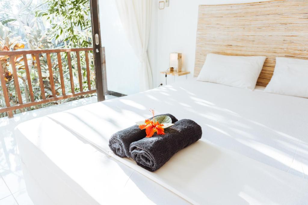 un asciugamano su un letto in una stanza di Sultans Of Swell Uluwatu Bali a Uluwatu