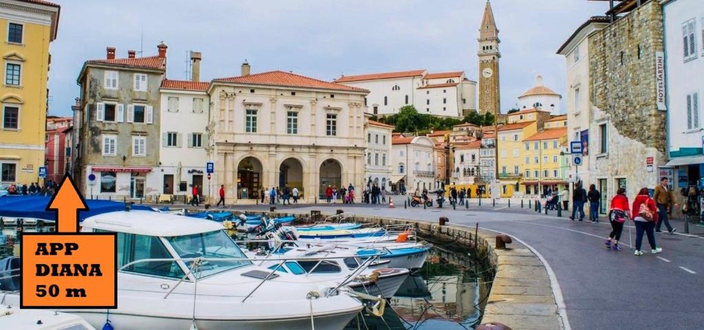 un grupo de barcos estacionados en un puerto deportivo en una ciudad en Apartments Diana Piran, en Piran