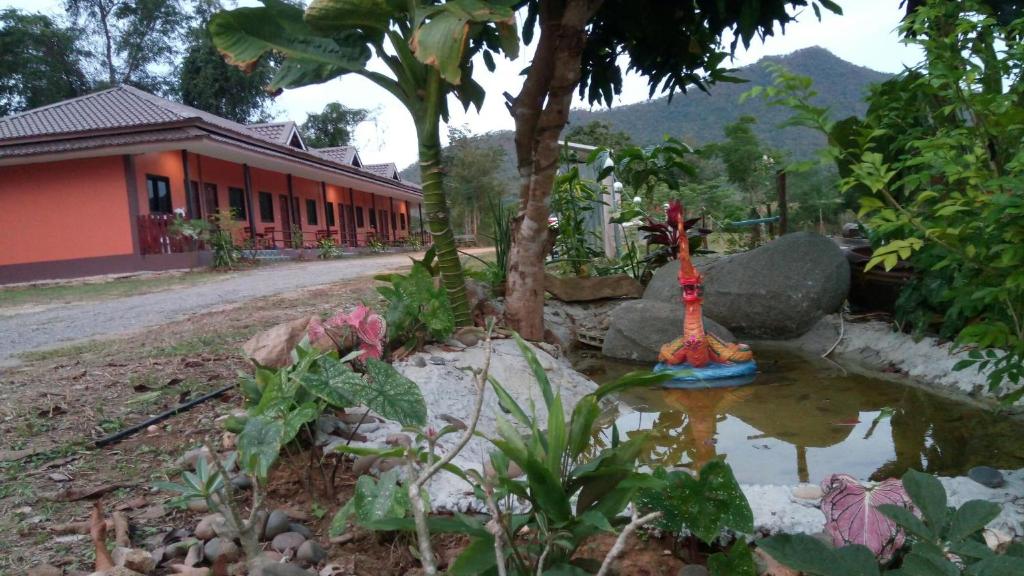 a garden with a pond in front of a building at ปันสุขรีสอร์ท in Loei