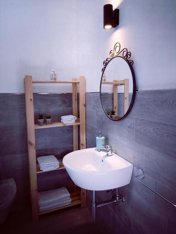 a bathroom with a white sink and a mirror at La Foresteria in Grottaglie