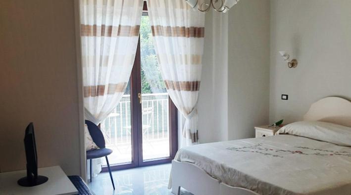 a bedroom with a bed and a large window at Domus In Fonte in Scafati