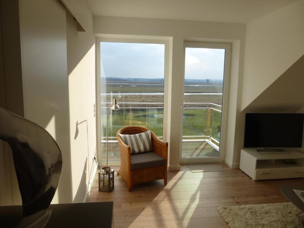 a living room with a chair and a large window at Sterntaucher in Hohwacht