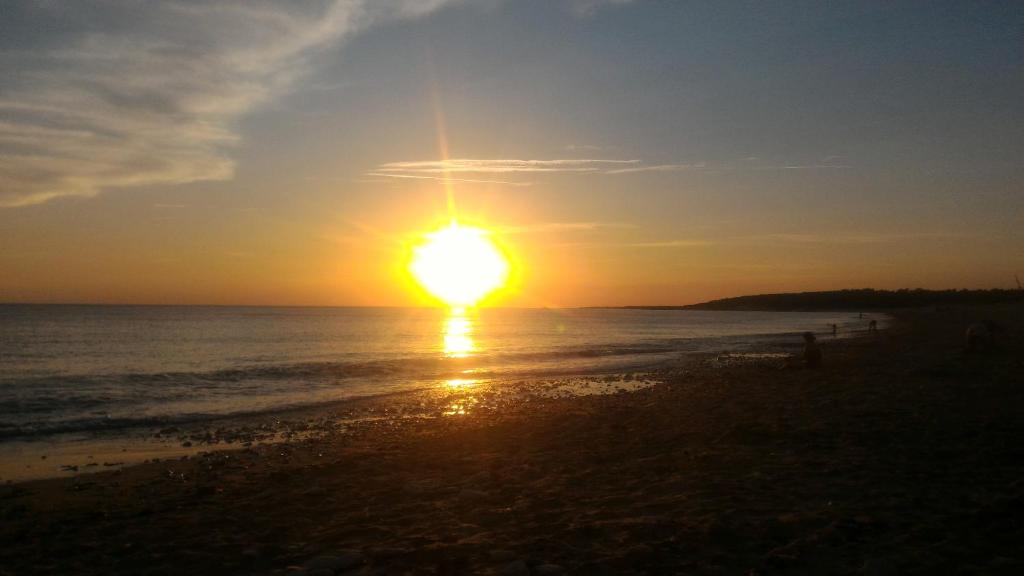 a sunset on the beach with the sun setting at Ma Maison in Le Château-dʼOléron