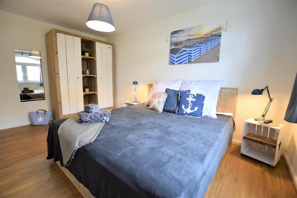 a bedroom with a large bed with blue pillows at Familie-Anker-Kiefernweg-4-H in Hohwacht