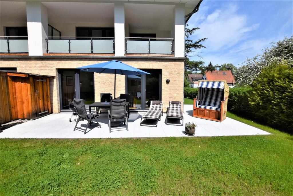 a patio with a table and chairs and an umbrella at Seestern in Hohwacht