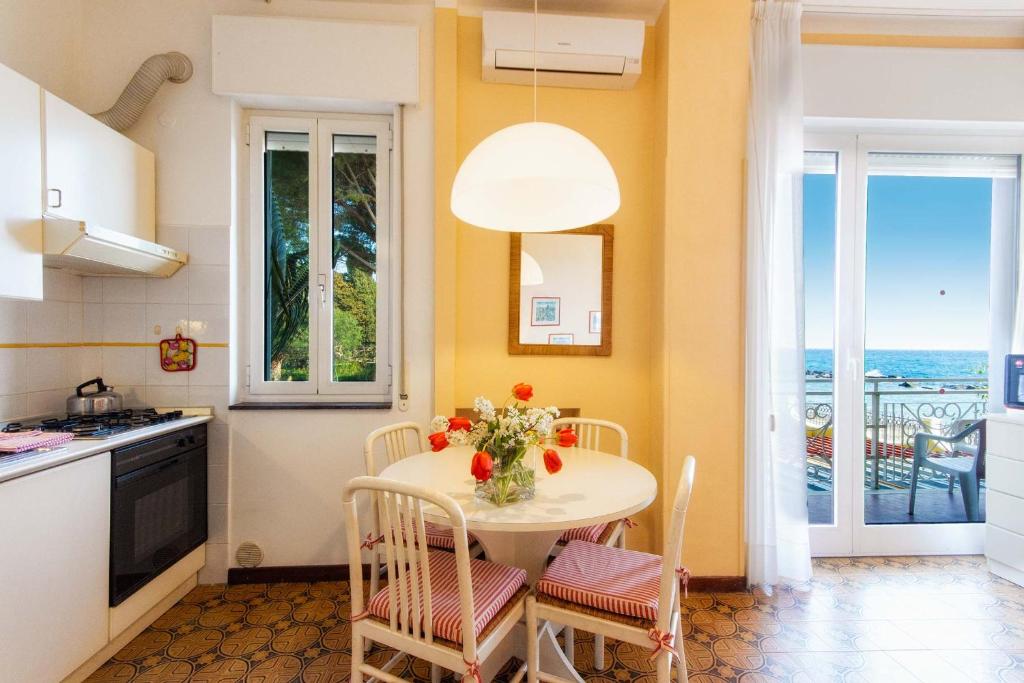 a kitchen with a table with a vase of flowers on it at Villa Marina Apartments in Diano Marina