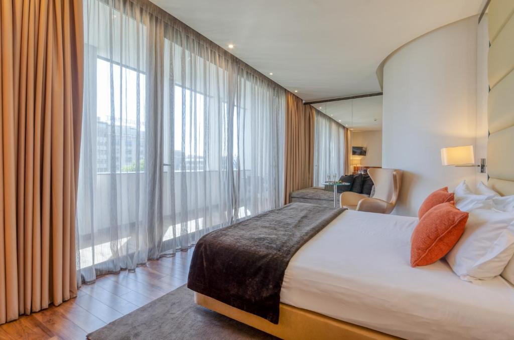 a hotel room with a bed and a large window at TURIM Av. Liberdade Hotel in Lisbon