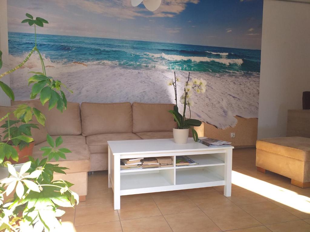 a living room with a couch and a painting of the beach at Bryza Międzyzdroje in Międzyzdroje