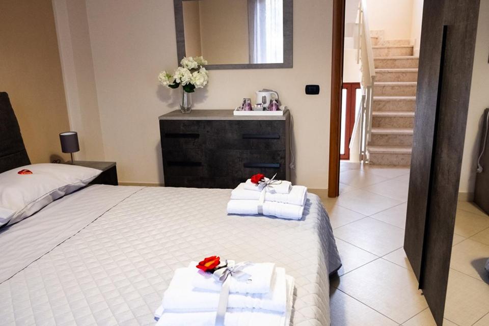een slaapkamer met een bed met handdoeken en een wastafel bij ALMI B&B in Sarno