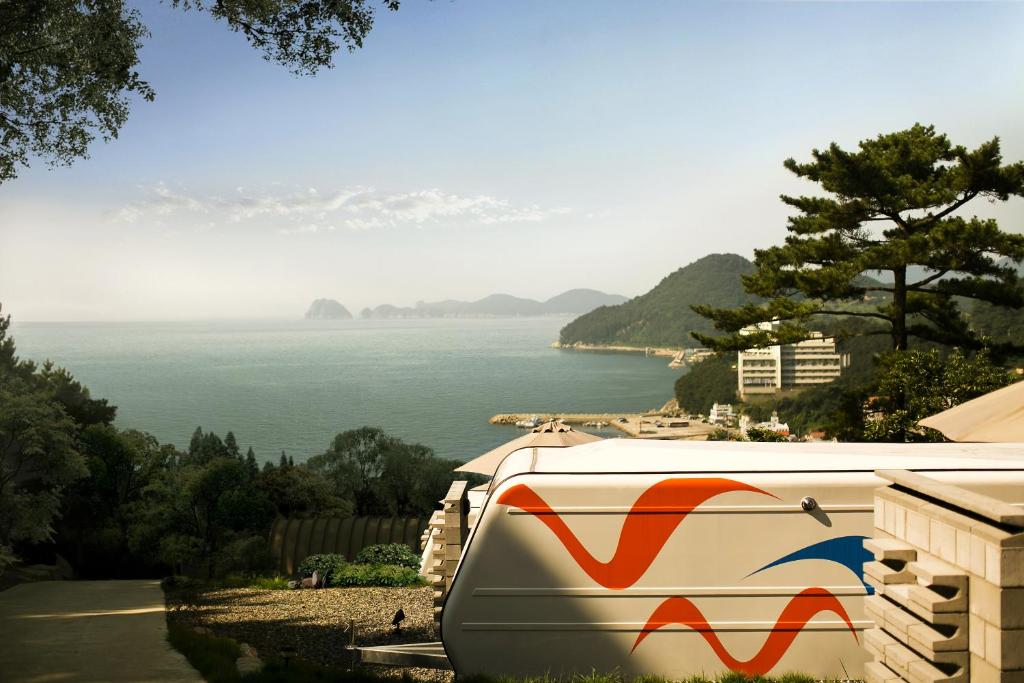 a train is parked next to a body of water at Tropical Dream Spa Caravan in Geoje