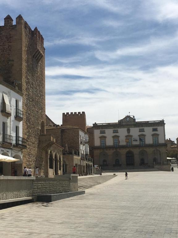 a group of buildings in a square with a sky at Apartamentos Turísticos Domus Seleqtia Plaza Mayor in Cáceres