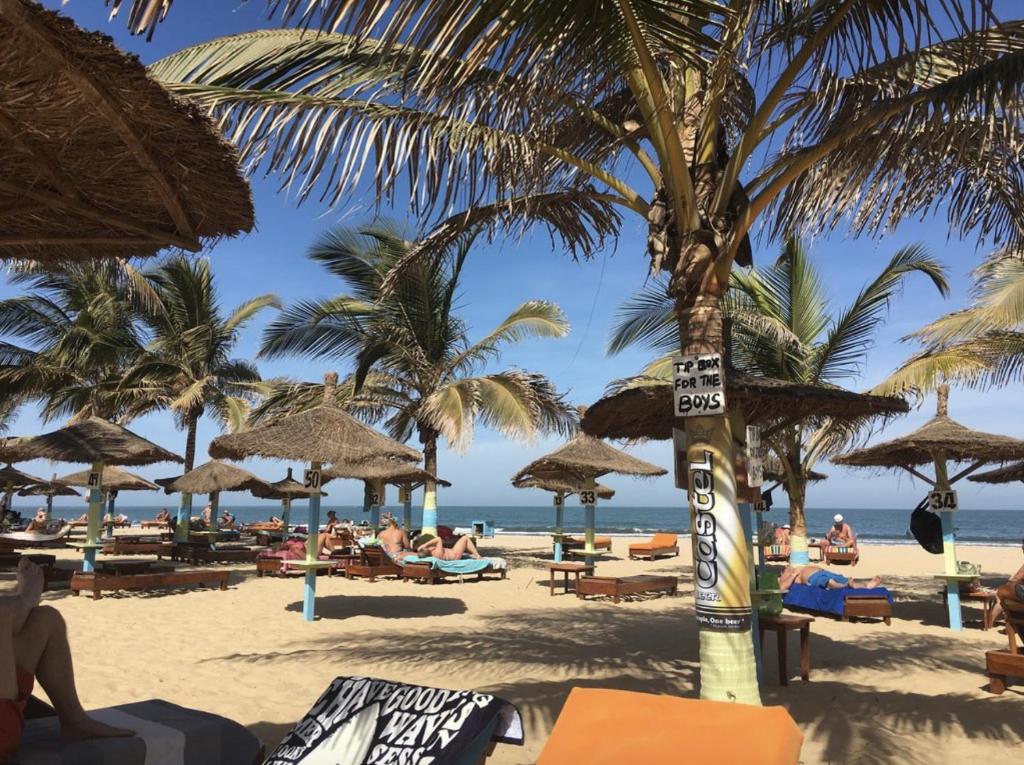 科图Kunta Kinteh Beach Complex的沙滩上,有草伞和人