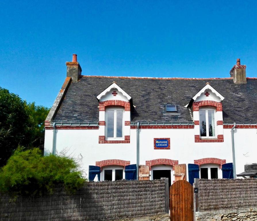 une maison blanche avec une clôture devant elle dans l'établissement Chez Marianne, à Quiberon