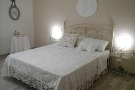ein Schlafzimmer mit einem großen weißen Bett mit zwei Lampen in der Unterkunft Sweet Home in La Spezia