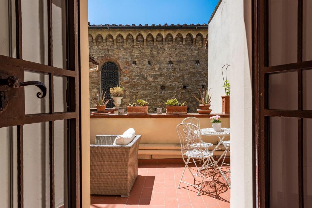 eine offene Tür zu einem Balkon mit einem Tisch und Stühlen in der Unterkunft B&B San Remigio in Florenz