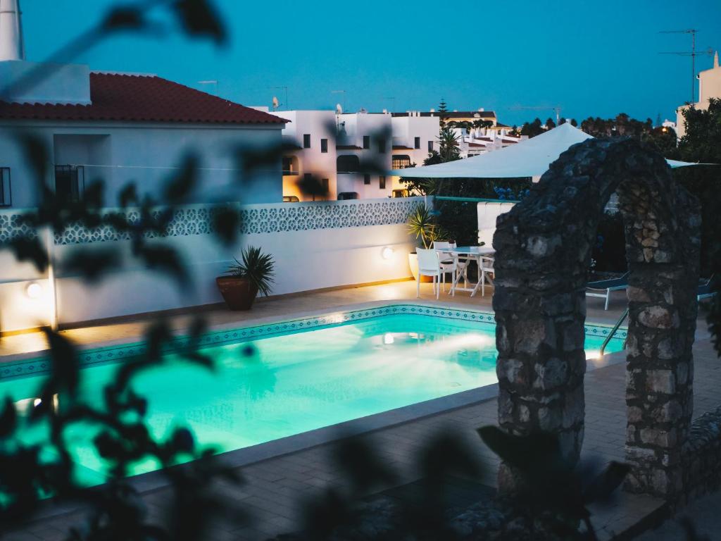 a swimming pool in front of a house at night at Vivenda Brito in Carvoeiro