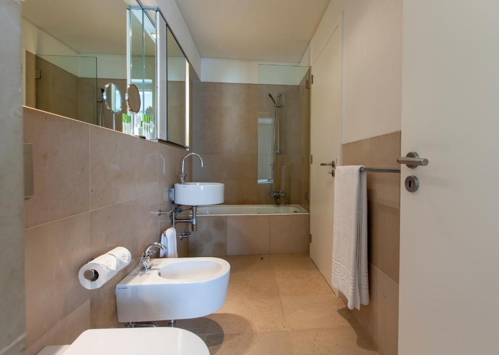 a bathroom with a sink and a toilet and a tub at Troia Residence by The Editory - Apartamentos Marina in Troia