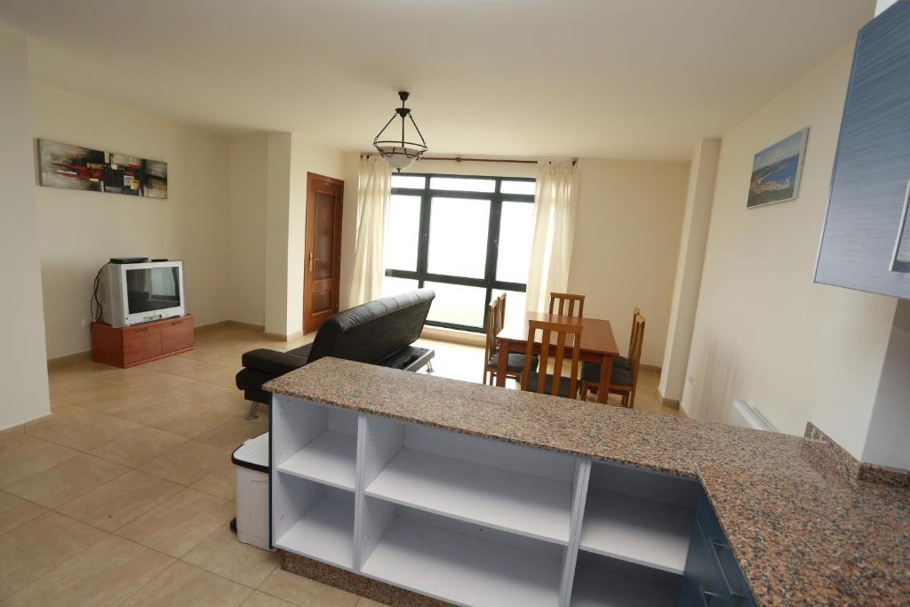 A television and/or entertainment centre at viviendas de uso turístico FINISTERRAE PLAYA