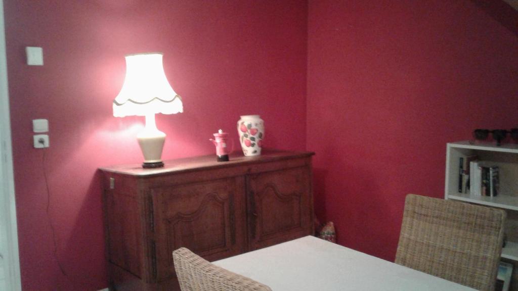 a table with a lamp on top of a red wall at Foreword House in Albert