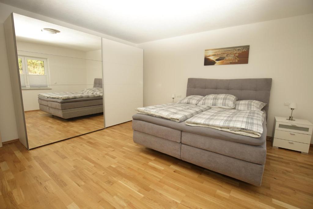 1 dormitorio con cama y espejo en Riethelblick, en Volkesfeld