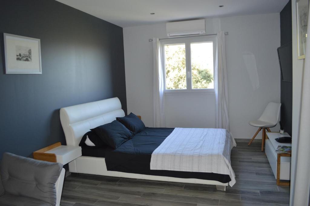 a bedroom with a bed and a window at La Villa Volpaso in Belgodère