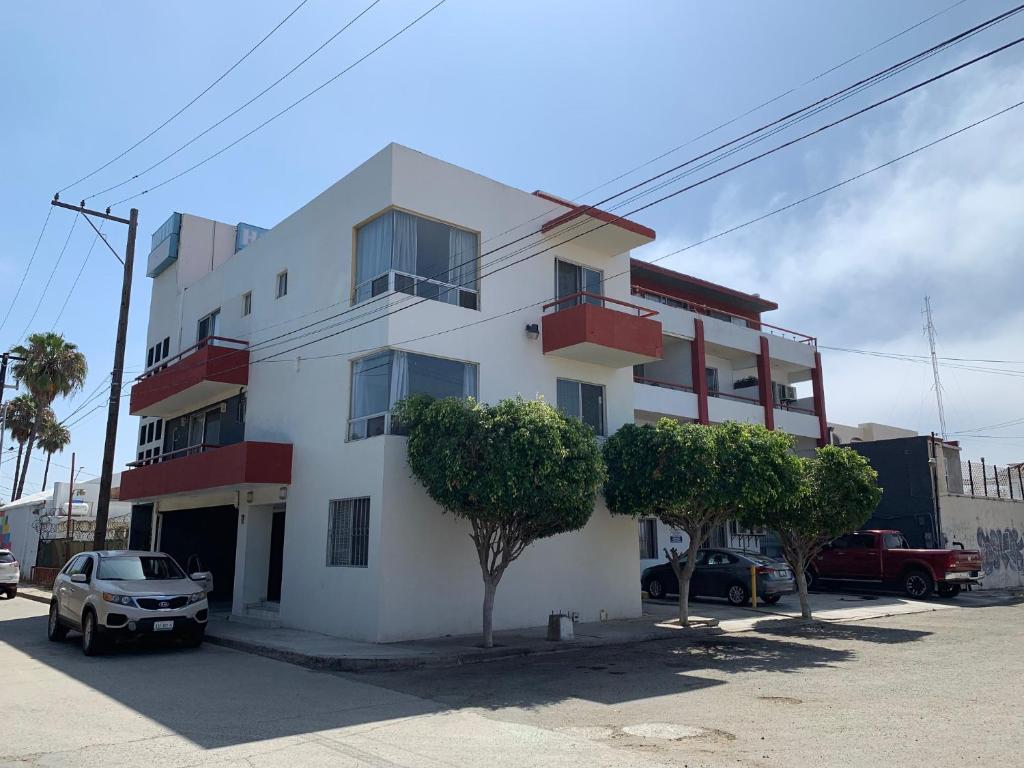 a white building with trees in front of it at Hotel Posada Don Fernando in Ensenada