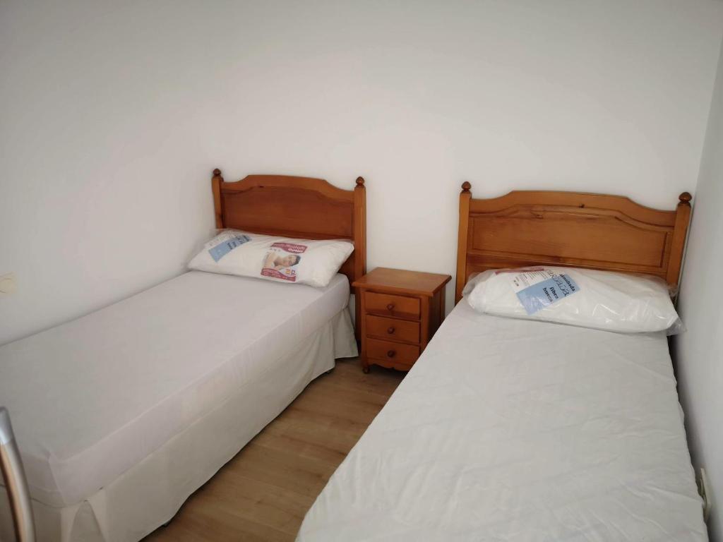 2 camas individuales en una habitación con mesita de noche y sidx sidx sidx en Apartamento Angeles - Playa de Gandia, en Gandía