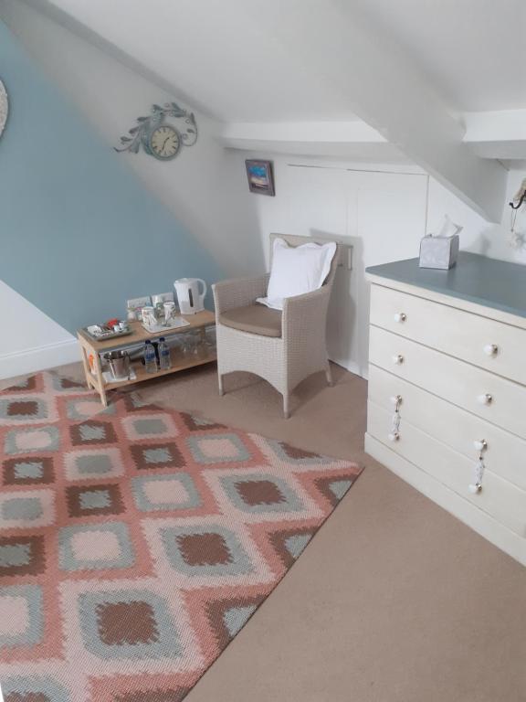 an attic room with a rug and a chair at The Bridges B&B in Broomhill