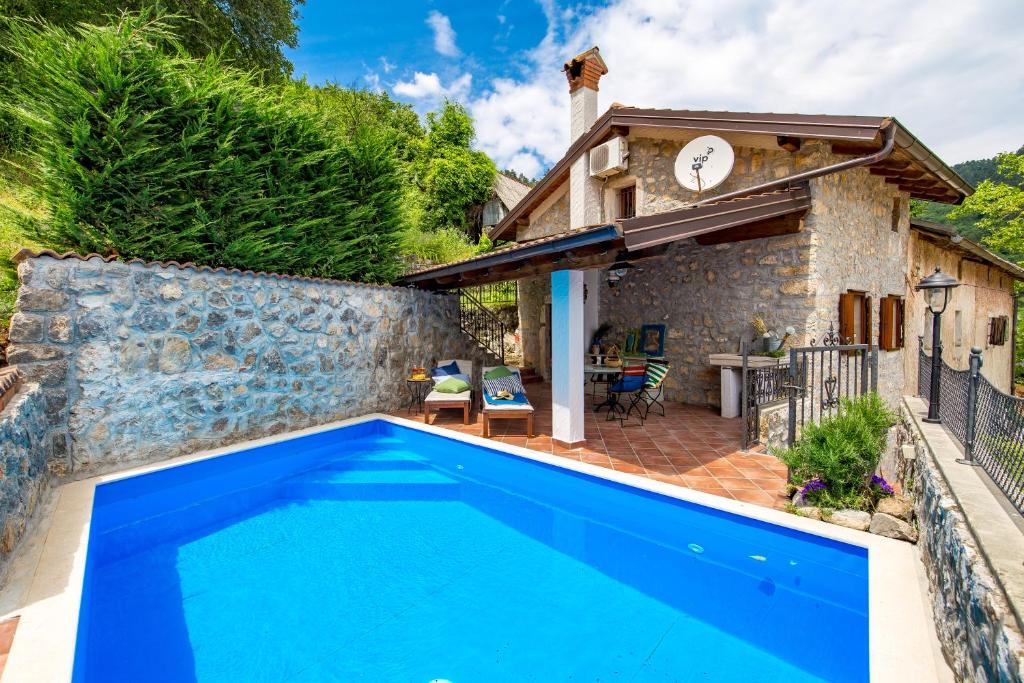 a pool in front of a house with a clock at House Pavincic in Lovran
