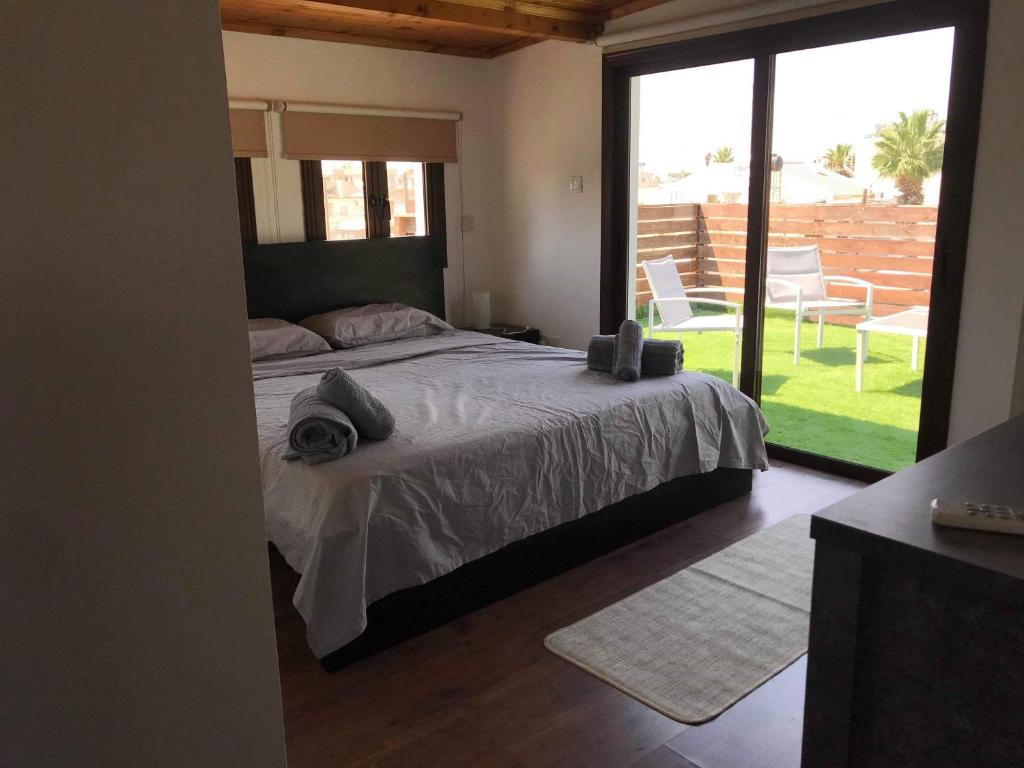 a bedroom with a bed and a large window at Town centre suites in Larnaka