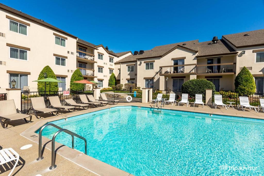 una piscina en un patio con sillas y apartamentos en condominio en Club Hotel Nashville Inn & Suites en Nashville