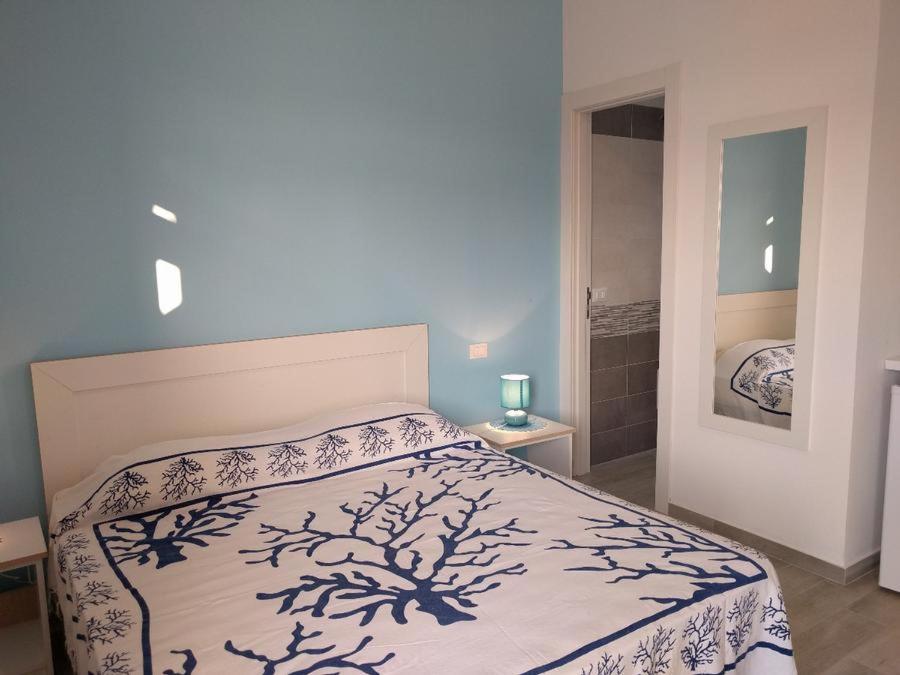 a bedroom with a bed with a white comforter at La Bussola in Porto Cesareo