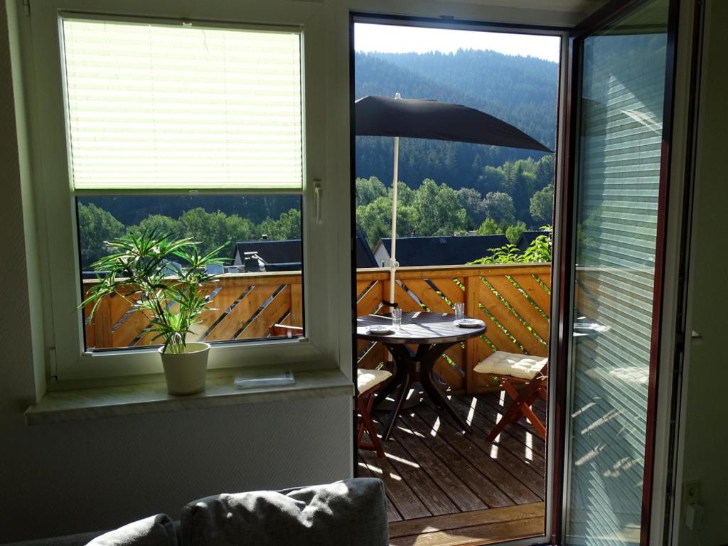 vista su un balcone con tavolo e ombrellone di Ferienwohnung am Berggrabenweg a Ilmenau