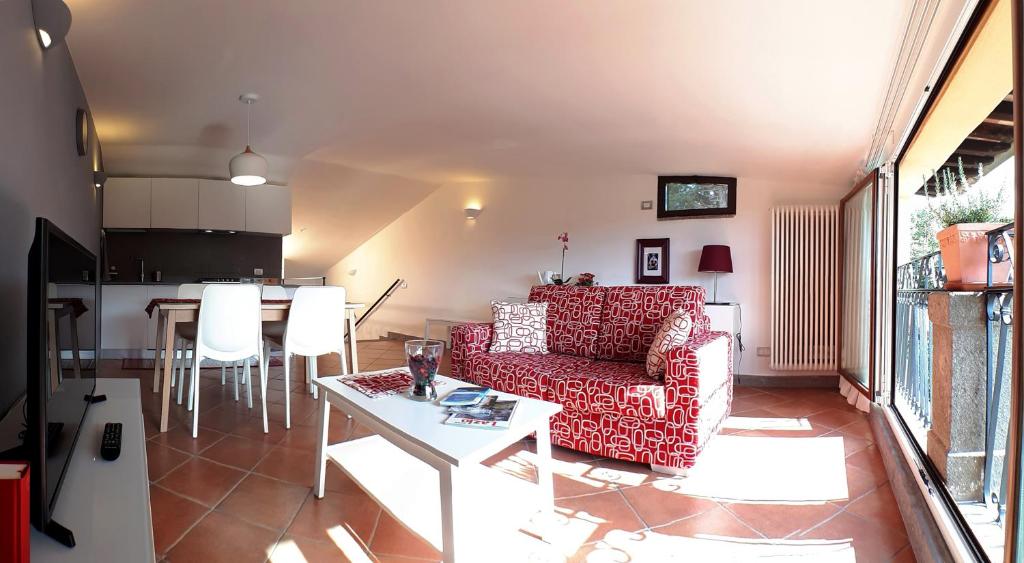 a living room with a red couch and a table at Alloggio turistico La Casa del Vignola in Viterbo