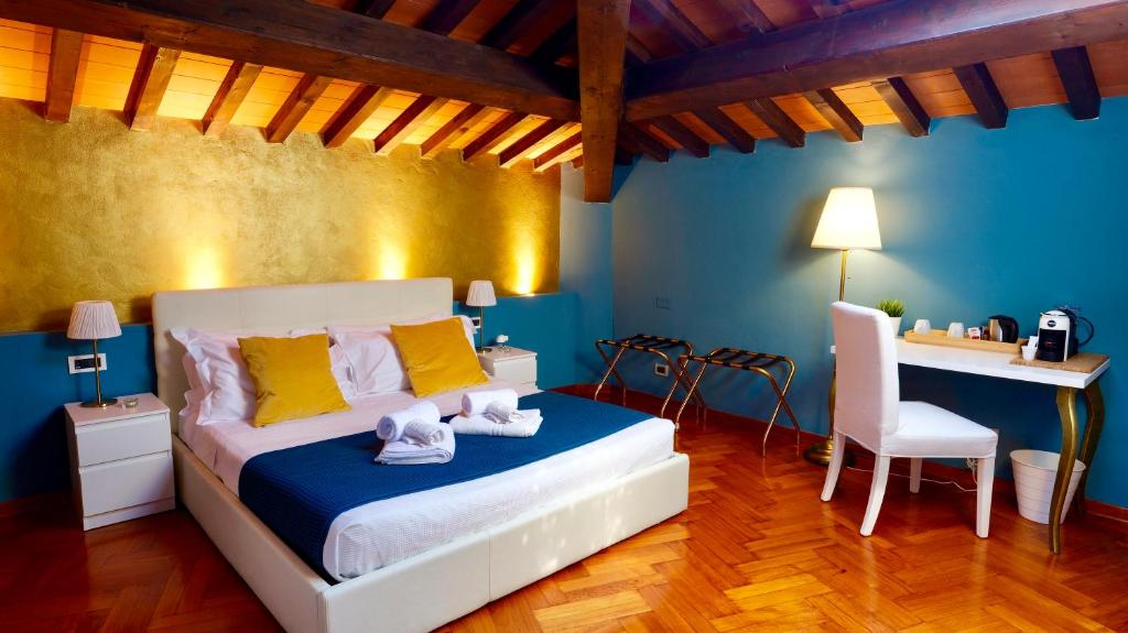 a bedroom with a bed with a desk and a chair at Villa Martina Classic & Luxury Room in Pisa