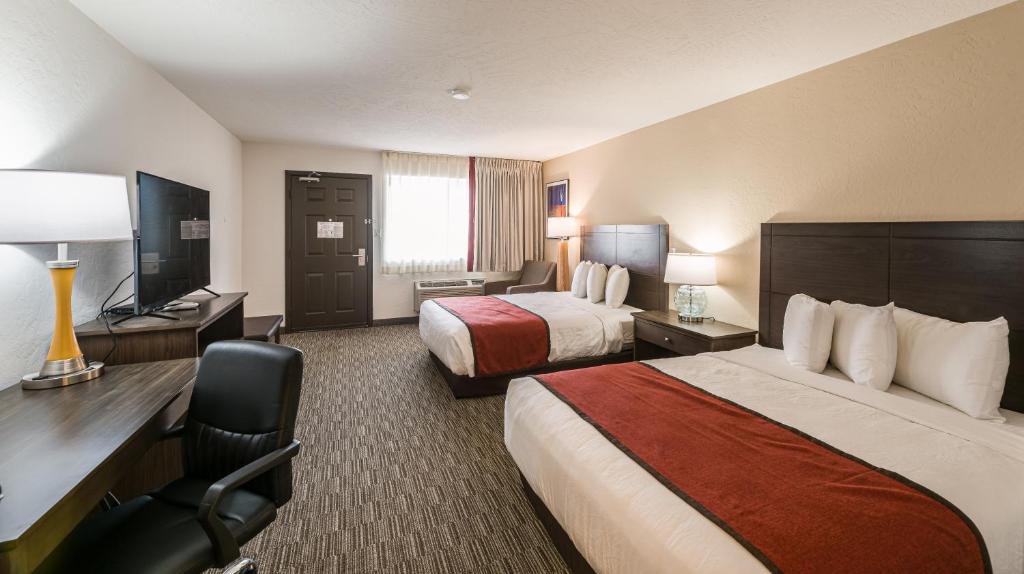 a hotel room with two beds and a desk at Lux Verde Hotel in Cottonwood
