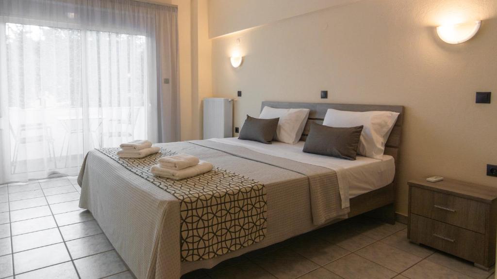 1 dormitorio con 1 cama grande y 2 toallas. en Pravi Hotel, en Eleftheroúpolis