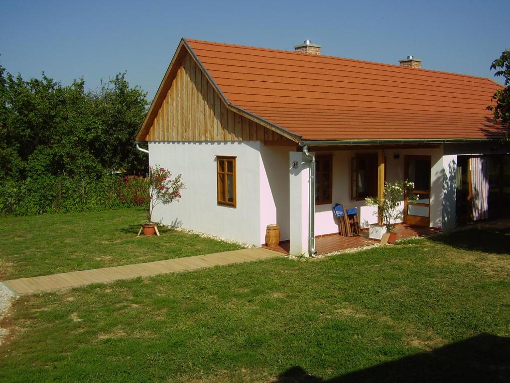 una pequeña casa blanca con techo rojo en Martonvendeghaz 1, en Erdeimajor