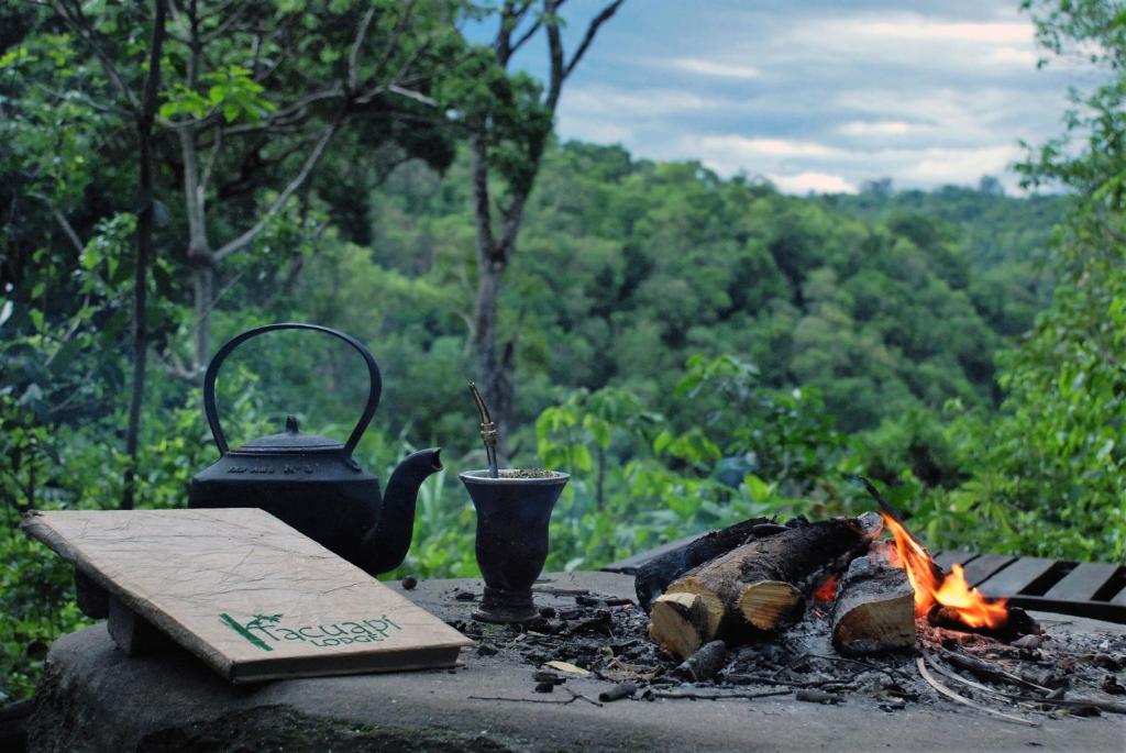 a campfire with a tea kettle and a tea pot at Tacuapí Lodge in Aristóbulo del Valle