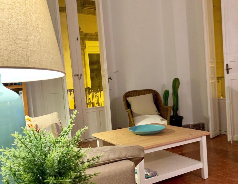 un soggiorno con tavolo e divano di Luz y Sencillez en el Centro Histórico de Málaga a Málaga