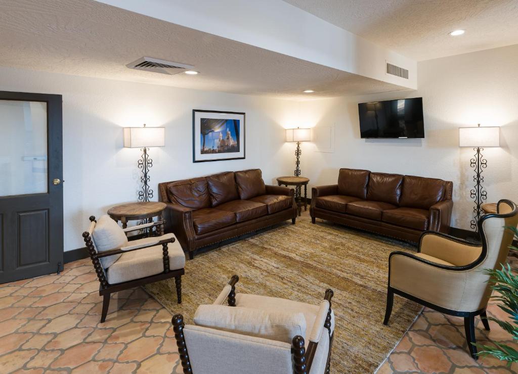 a living room with brown leather furniture and a flat screen tv at Lux Verde Hotel in Cottonwood