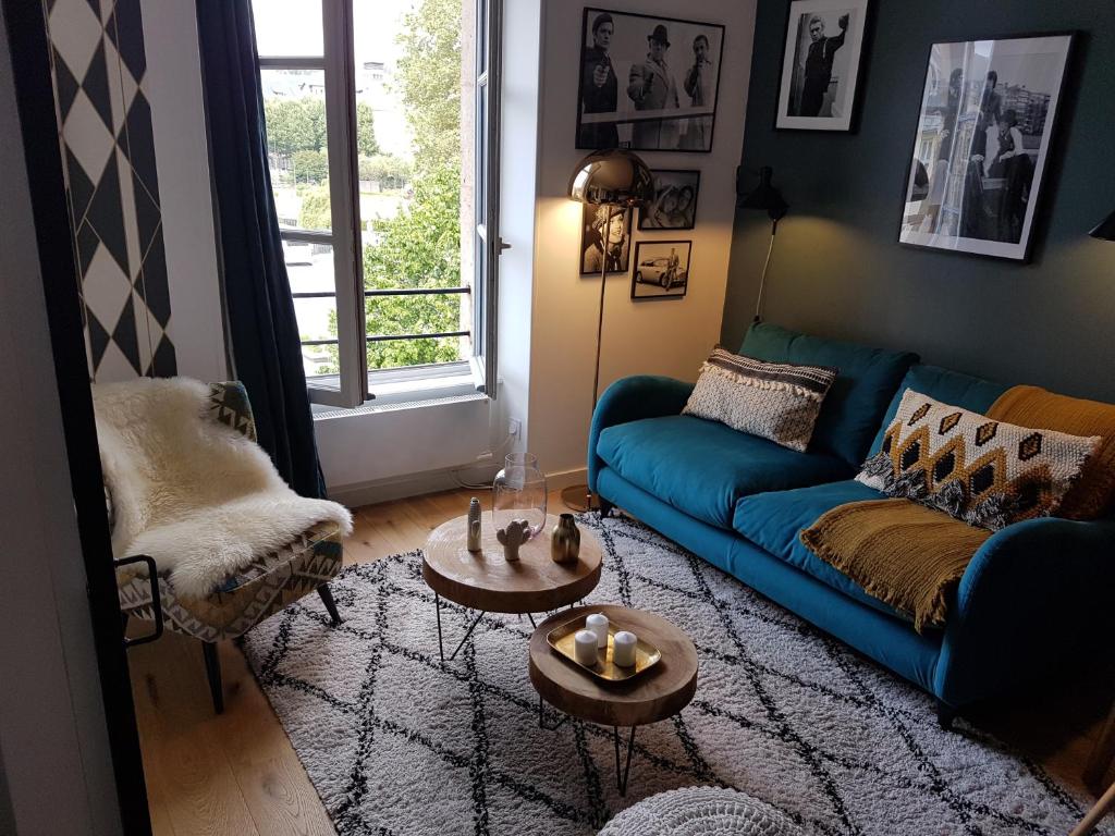 a living room with a blue couch and a table at Fiquet de Normanville pour votre bien être en plein coeur historique in Rouen