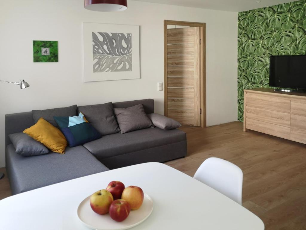 a living room with a couch and a table with apples on it at Green leaf apartments in Liepāja