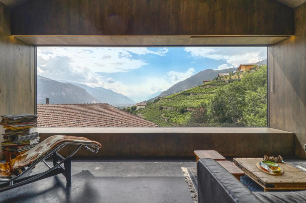 a room with a large window with a view of a mountain at Renovated historic barn in mountain village in Ollon